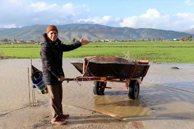 Sular altında kalan tarlasını kayıkla gezdi