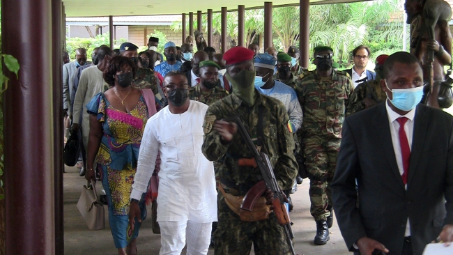 Darbe liderleriyle görüşmenin ardından ECOWAS heyeti askerler eşliğiyle karargahtan ayrıldı. Fotoğraf: Reuters