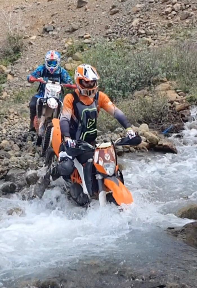 Motosikleti ile karlı dağlara çıktı, kayak yaparak indi