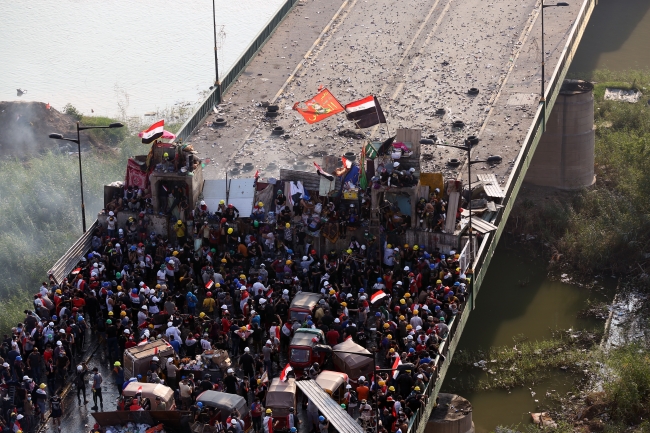 Başkent Bağdat'taki Tahrir Meydanı'nda toplanan on binlerce kişi gösteri düzenledi. Eyleme katılan bazı göstericiler, Cumhuriyet Köprüsü'nden Tahrir Meydanı'na giden yolu barikatlarla kapattı. Fotoğraf: AA