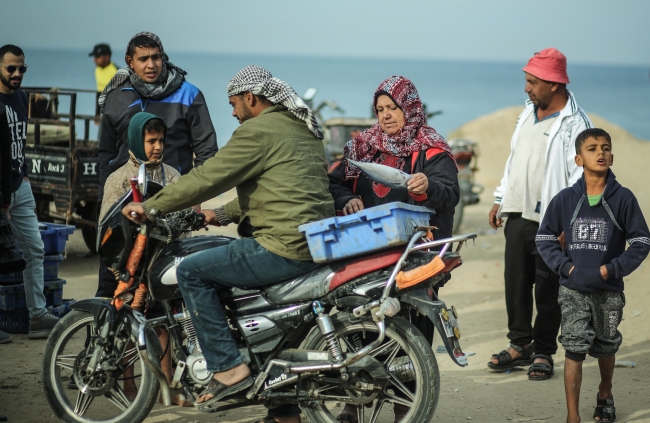 Gazze'deki balık pazarında uzun yıllardır Ümmü Cemil el-Ekra'nın sesi yankılanıyor. Fotoğraf: AA