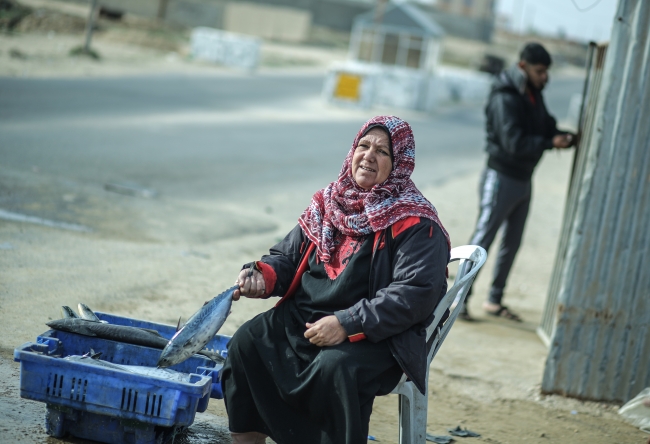 Gazze'deki balık pazarında uzun yıllardır Ümmü Cemil el-Ekra'nın sesi yankılanıyor. Fotoğraf: AA