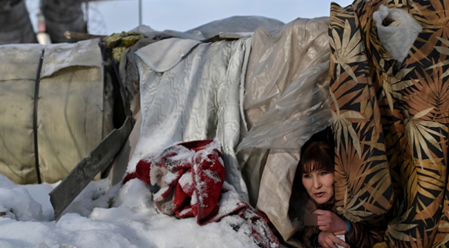 Lyusya Stepanova, borulara geçirilmiş battaniyelerin arasında dışarıya bakıyor (Fotoğraf: Reuters)