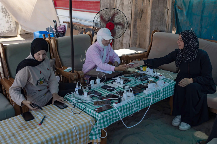 Han Yunus'ta güneş panelleriyle çalışan bir cep telefonu şarj istasyonu.