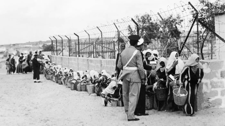 Filistinli mülteciler, 9 Kasım 1956'da Gazze'deki bir kampta Unrwa tarafından dağıtılan yiyecek kuyruğunda (AFP)